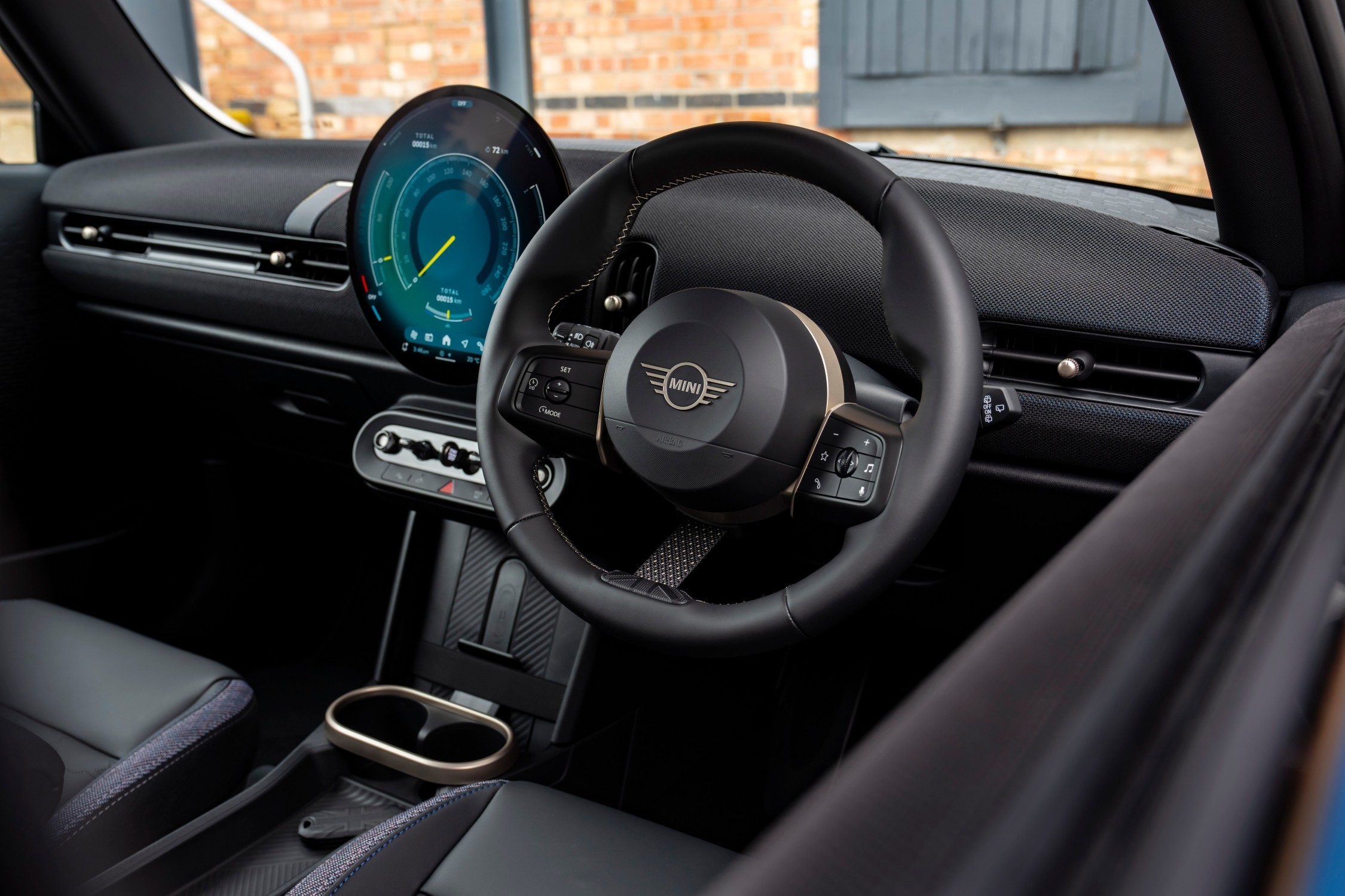 Interior do MINI Cooper Oxford Edition, com volante, ecrã central circular e consola em destaque